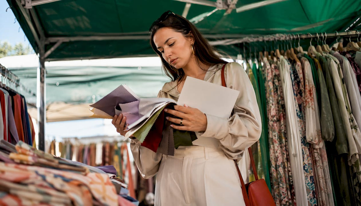 Buyer examining Italian womenswear fabrics in showroom