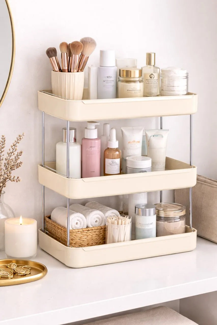 Beige multi-tiered organizer with beauty products on a white surface.