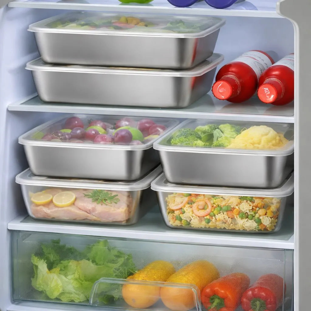 Stainless steel food containers and fresh produce inside a refrigerator.
