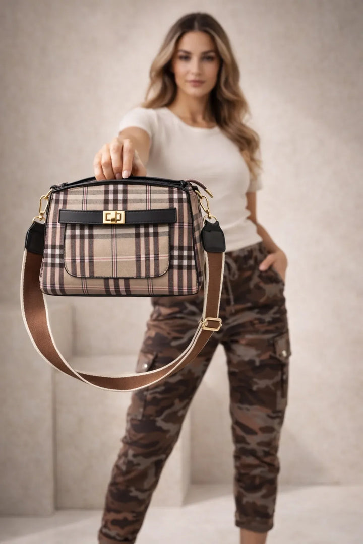 Woman holding a plaid handbag against a neutral background