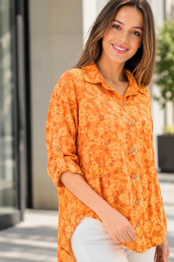 Woman wearing an orange floral blouse outdoors
